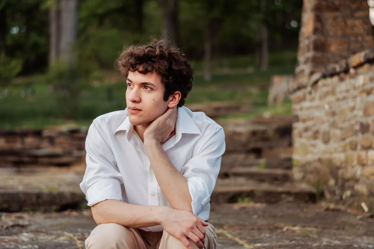 Senior boy in a white shirt posing thoughtfully at the South Park cascades