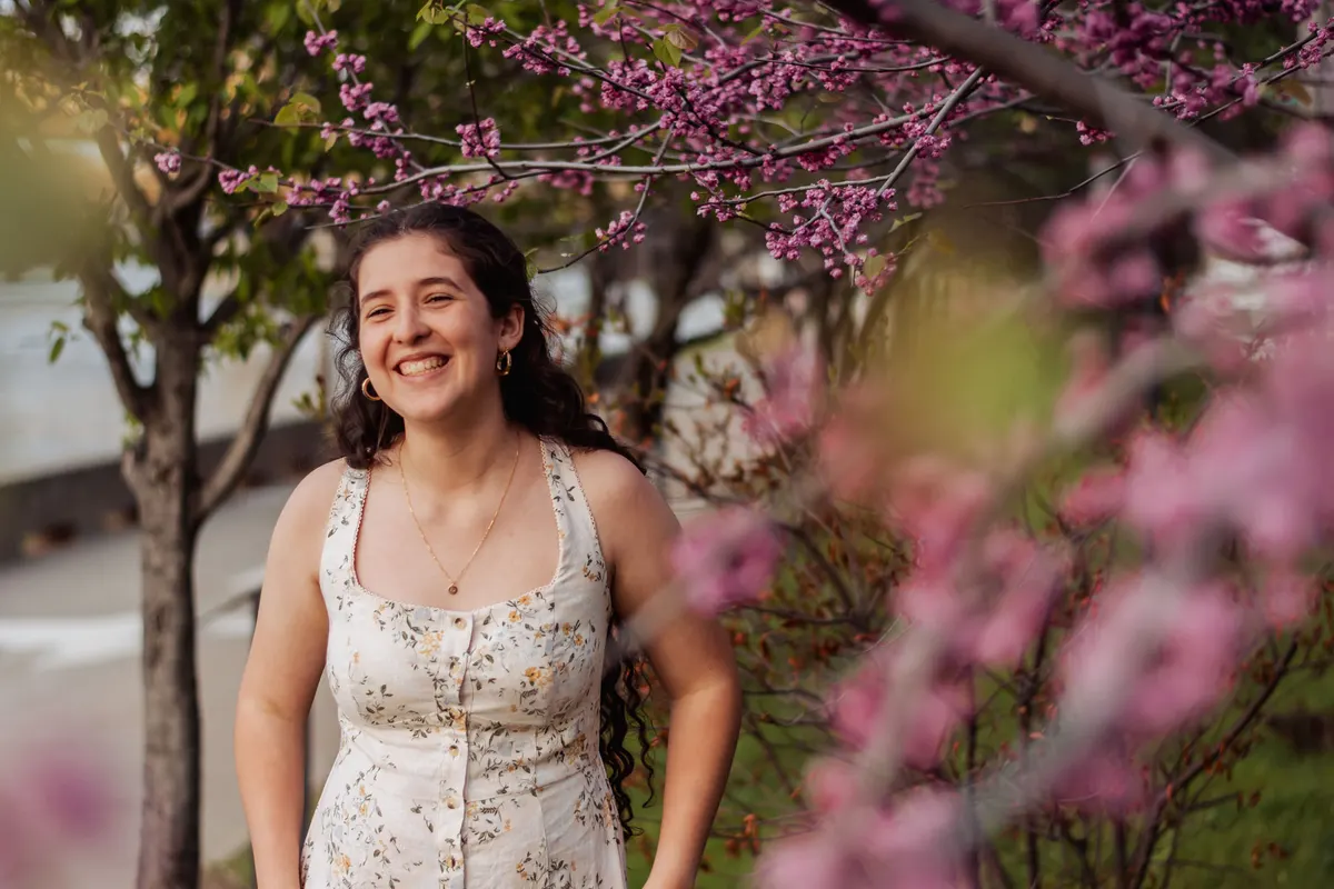 Senior framed by pink redbud blossoms in downtown Pittsburgh