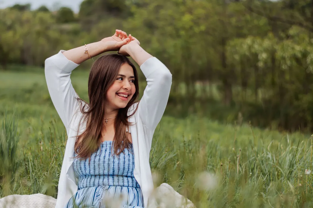 High school senior laughing in a green field at Boyce Mayview Park in Upper St. Clair